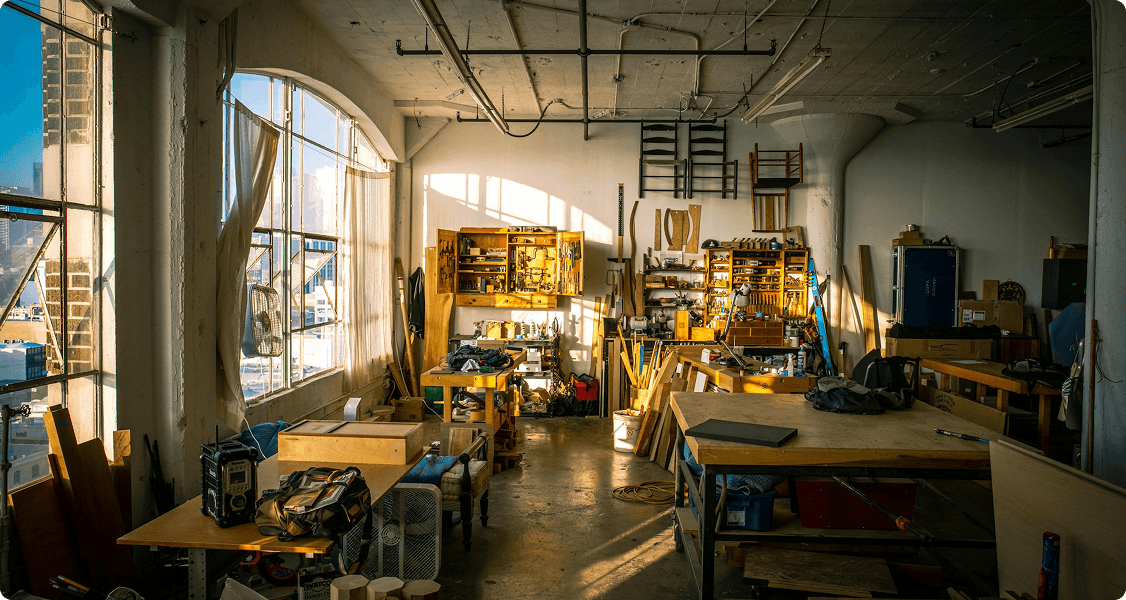 A vibrant woodworking room brimming with tools, wood shavings, and unfinished projects, inviting creativity and craftsmanship.