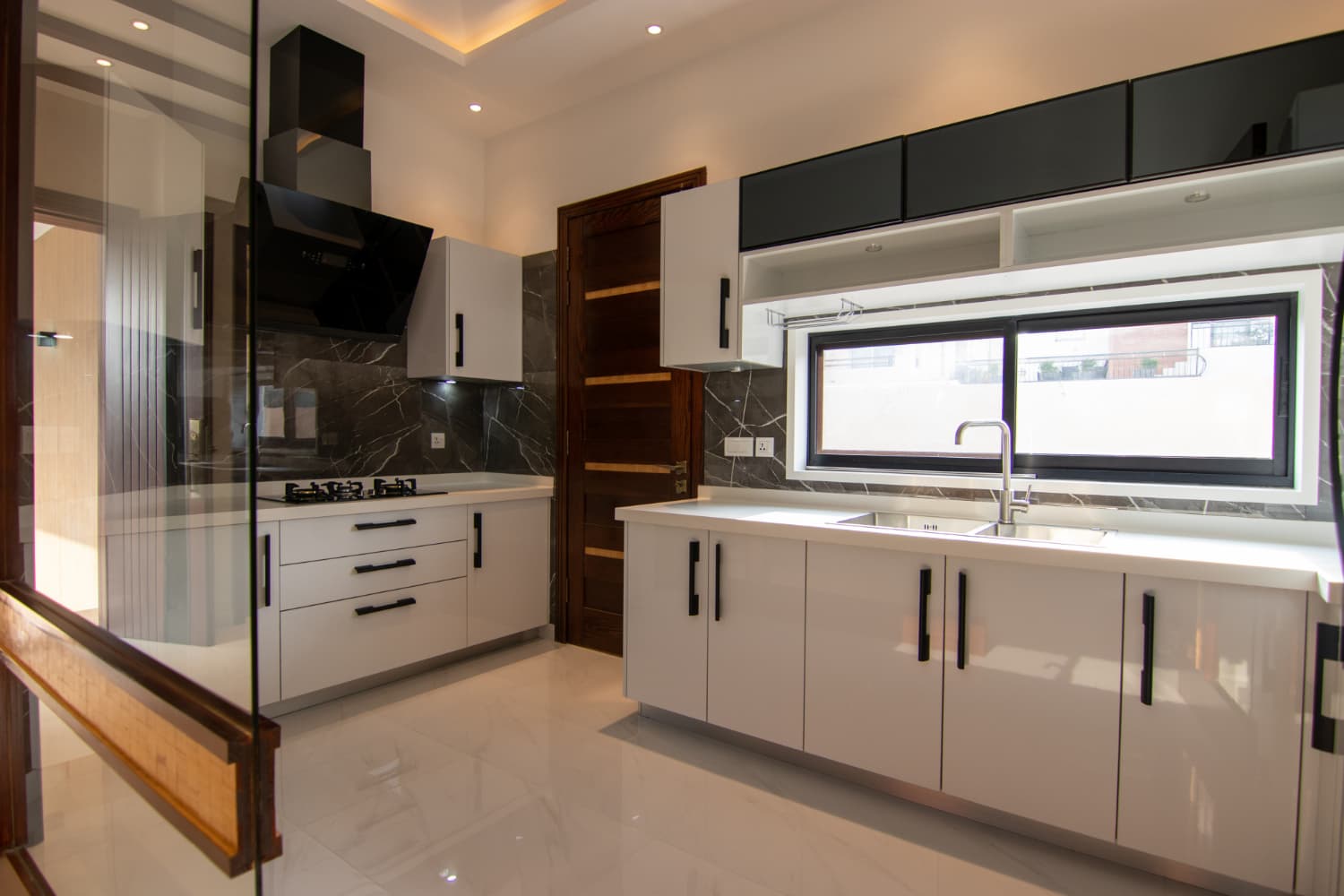 A sleek modern kitchen featuring white cabinets and striking black countertops, creating a stylish and contemporary atmosphere.